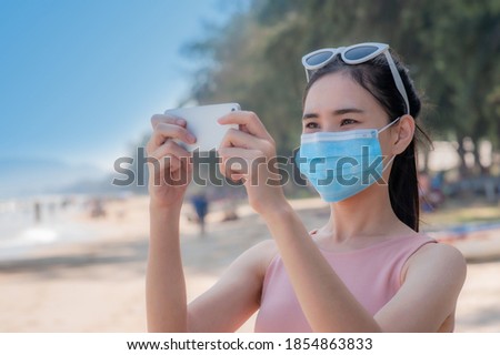 Asian women wear medical mask travel on beach sea Thailand, New normal Thai people travel in Thailand