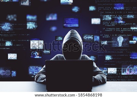 Hacker using laptop computer with digital business interface hologram. Hacking and cyber attack concept. Multiexposure