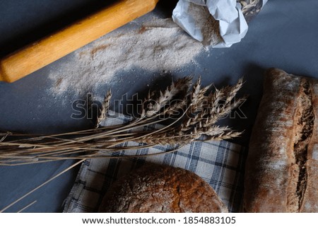 Homemade bread at small bakery with flower and rye on linen napkin. Fresh crispy french bread, rustic style concept food photography, space for text. 