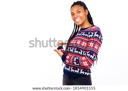 Young beautiful African American woman wearing Christmas sweater against white wall Inviting to enter smiling natural with open hands. Welcome sign.