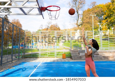 Female basketball player throws the ball into the basket