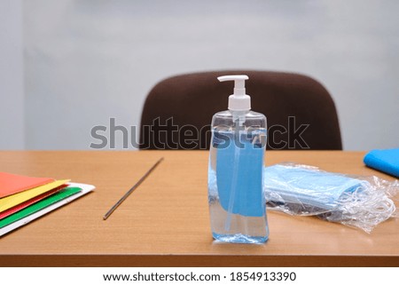 School table with virus protection products - medical masks and sanitizer, nobody. Education during the coronavirus epidemic
