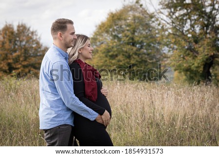 Happy couple waiting for childbirth making memories outdoor. Pregnancy photo shooting