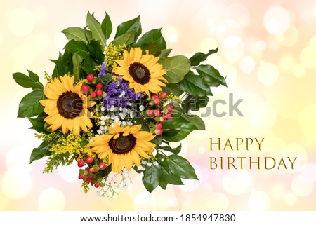 Happy birthday card design with a gorgeous blooming bouquet of sunflowers on a bright abstract delicate pastel blurred background.