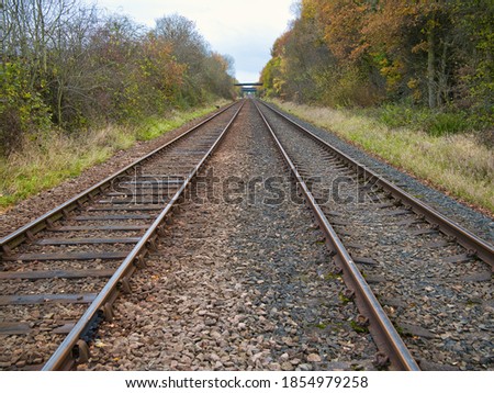 The tracks of two railway lines converge into the distance on an autumn day. Taken on Wirral in the north west of the UK. Royalty-Free Stock Photo #1854979258