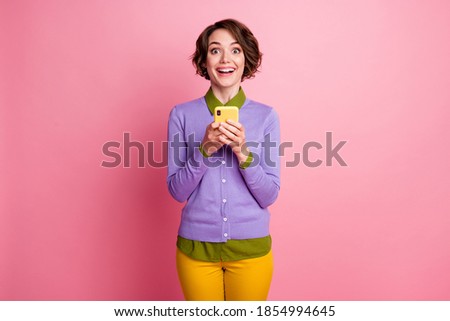 Photo of funny lady hold telephone chatting friends wear purple jumper pants isolated pink color background