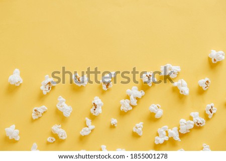 Popcorn on a yellow background as a background image. Top view. Copy, empty space for text