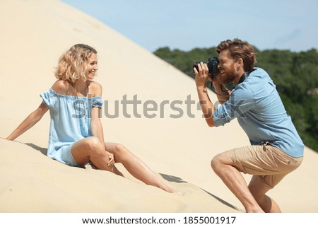 photographer with camera taking picture of beautiful woman