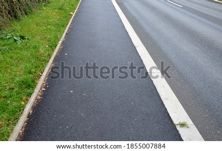 soundproof wall made of wooden slat concrete fence made of gray blocks on the street. noise from road traffic does not get into the garden, park. sidewalk of beige fine gravel asphalt surface