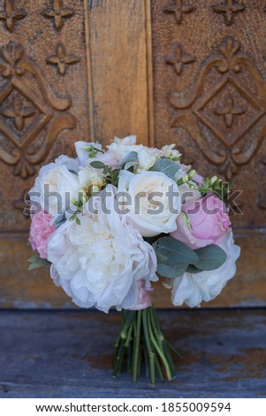 bouquet of pink flowers, white flowers and greenery is on the wooden background. wedding Floristics. Stylish bouquet of roses, peonies and branches of eucalyptus