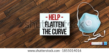 lightbox with message HELP FLATTEN THE CURVE with face masks on wooden background