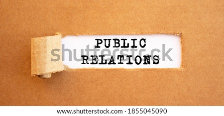 Text PUBLIC RELATIONS appearing behind torn brown paper.
