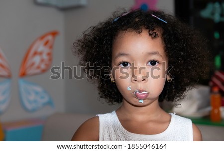 Portrait little African Asian girl eating a cake, cute little child girl eating cake. kids eat dessert.