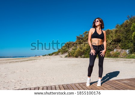 beautiful young girl with sunglasses walking on beach walkway