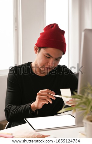 A male graphic designer is working on colour selection and digital tablet at workplace.