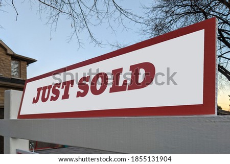 Just sold sign in front of detached house in residential area. Real estate bubble, sold over asking, crash, hot housing market, overpriced property, overpaid, buyer activity concept. Selective focus.
