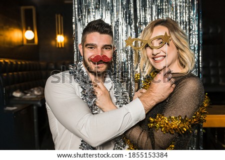 Portrait of happy young couple posing together at nightclub