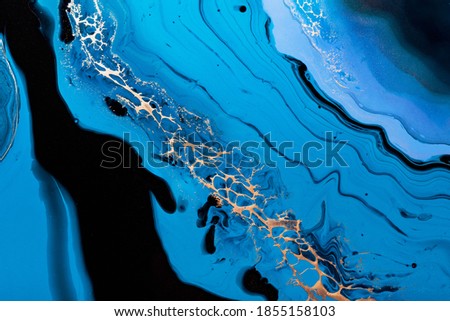 Fluid Art. Liquid Metallic Gold in abstract blue wave. Marble effect background or texture.