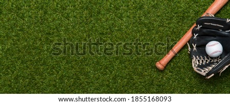 Baseball bat, glove and ball on green grass field.  Sport theme background with copy space for text and advertisment Royalty-Free Stock Photo #1855168093