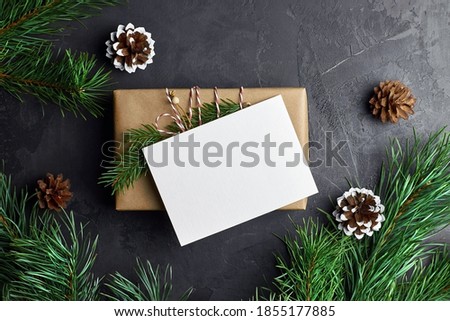 Christmas card mockup with gift box and pine tree branches with cones