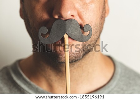Close up of a man wearing a prop black mustache