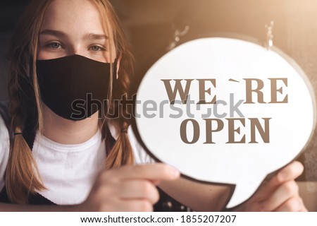 Coronavirus covid 19.Coffee shop woman owner with face mask, open after lockdown quarantine.End quarantine. Announcement we are open nv doors,  resumption shops, cafes,coffee houses, small businesses