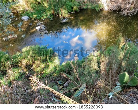 The blue sky's reflection on the OSO Creek in Orange County, California