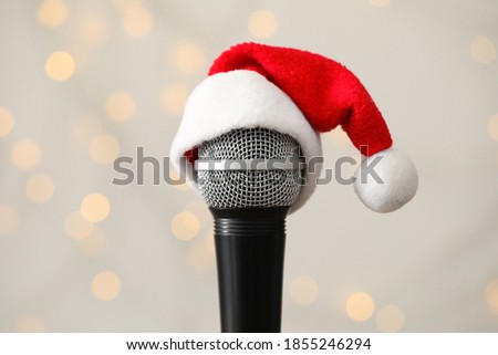 Microphone with Santa hat against blurred lights. Christmas music