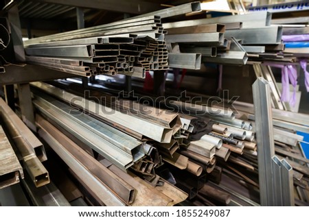 Metal profile of the pipe lies on the shelves in the workshop. High quality photo