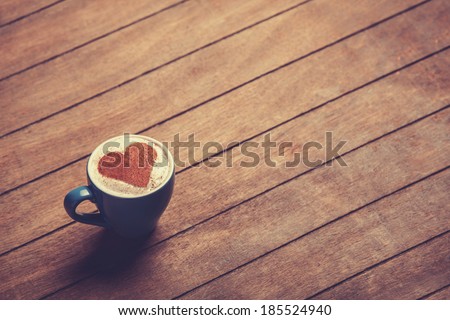 Cup of cÃ?Â�offee with shape heart on a wooden table.
