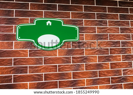 Green plaque for house number on a brick wall - address sign - place for inscription