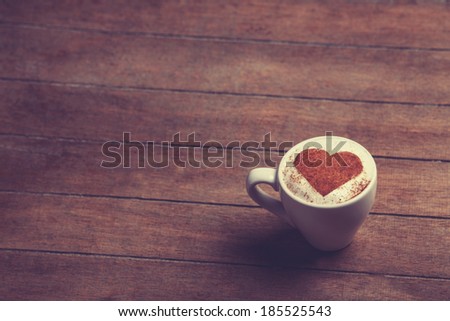 Cup of cÂ�offee with shape heart on a wooden table.