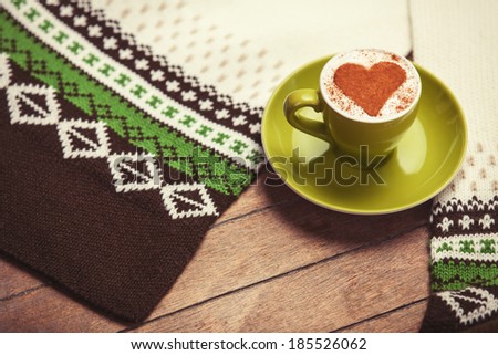 Cup of cÃ?Â�offee with shape heart and headscarf on a wooden table.