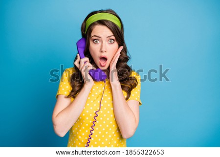 Photo portrait of woman touching face with hand open mouth talking over purple phone isolated on pastel light blue colored background
