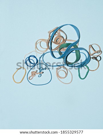 assorted rubber bands with different sizes and colours with blue background