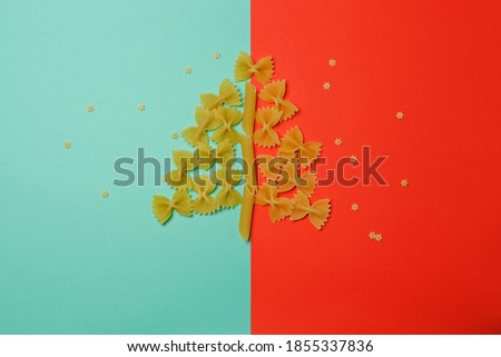 Christmas tree made from pasta on a red with a green background