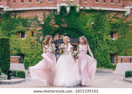 Pretty bridesmaids surround a bride holding wedding bouquets in their arms Royalty-Free Stock Photo #1855339102