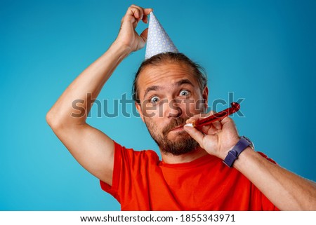 Funny long-haired bearded man in party cone