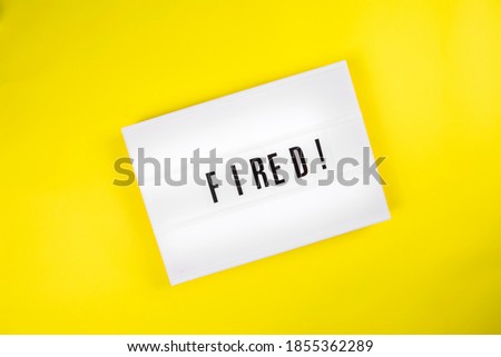 Fired! message on lightbox on yellow background isolated. Top view, flat lay. Economic crisis, downsizing, staff cuts, mass dismissals, job search, labor exchange, uncertainty about future concept