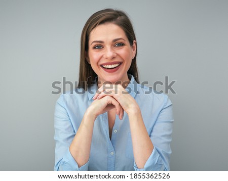 Young smiling woman in blue shirt portrait with folded hands.