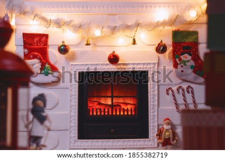 Fireplace with Christmas boxes. Fireplace decorated for Christmas with glowing fire and toys. New year concept design.