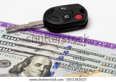 Car key, vehicle title and 100 dollar bills cash. Concept of automobile purchase, ownership, state and local taxes and fees Royalty-Free Stock Photo #1855383037