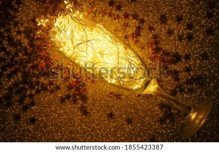 glasses on golden  background with Christmas lights - garland , happy New Year idea.