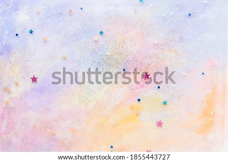 Glittery star confetti on colorful abstract pastel watercolor background Royalty-Free Stock Photo #1855443727