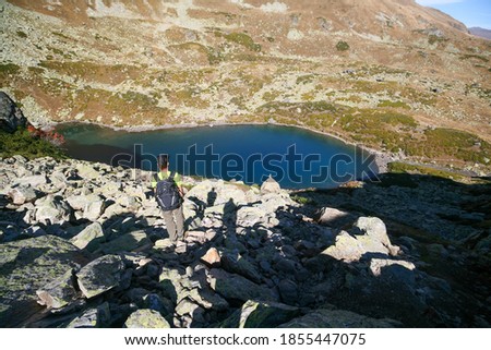 A tourist admires the mountain lake, Arkhyz, Russia.