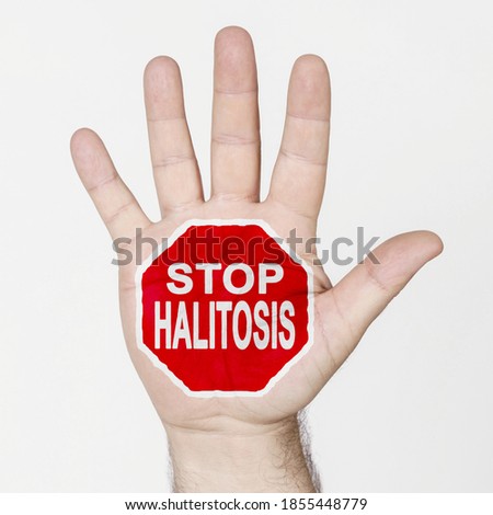Medicine concept. On the palm of the hand there is a stop sign with the inscription - STOP HALITOSIS. Isolated on white background.