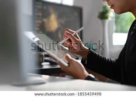 Cropped shot of a male creative designer is working with interactive pen and empty screen digital tablet at workstation.