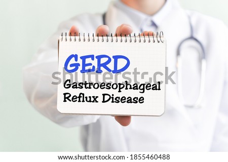 Doctor holding a card with text GERD Gastroesophageal Reflux Disease medical concept. The text is written in blue letters in a medical journal Royalty-Free Stock Photo #1855460488