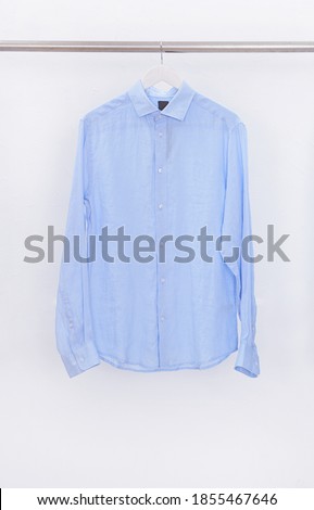 Men's long sleeved blue shirt close up on hanger
