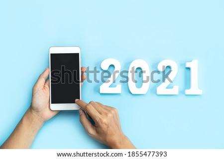 Hand holding empty screen smart phone on color background with 2021 new year concept and copy space Royalty-Free Stock Photo #1855477393